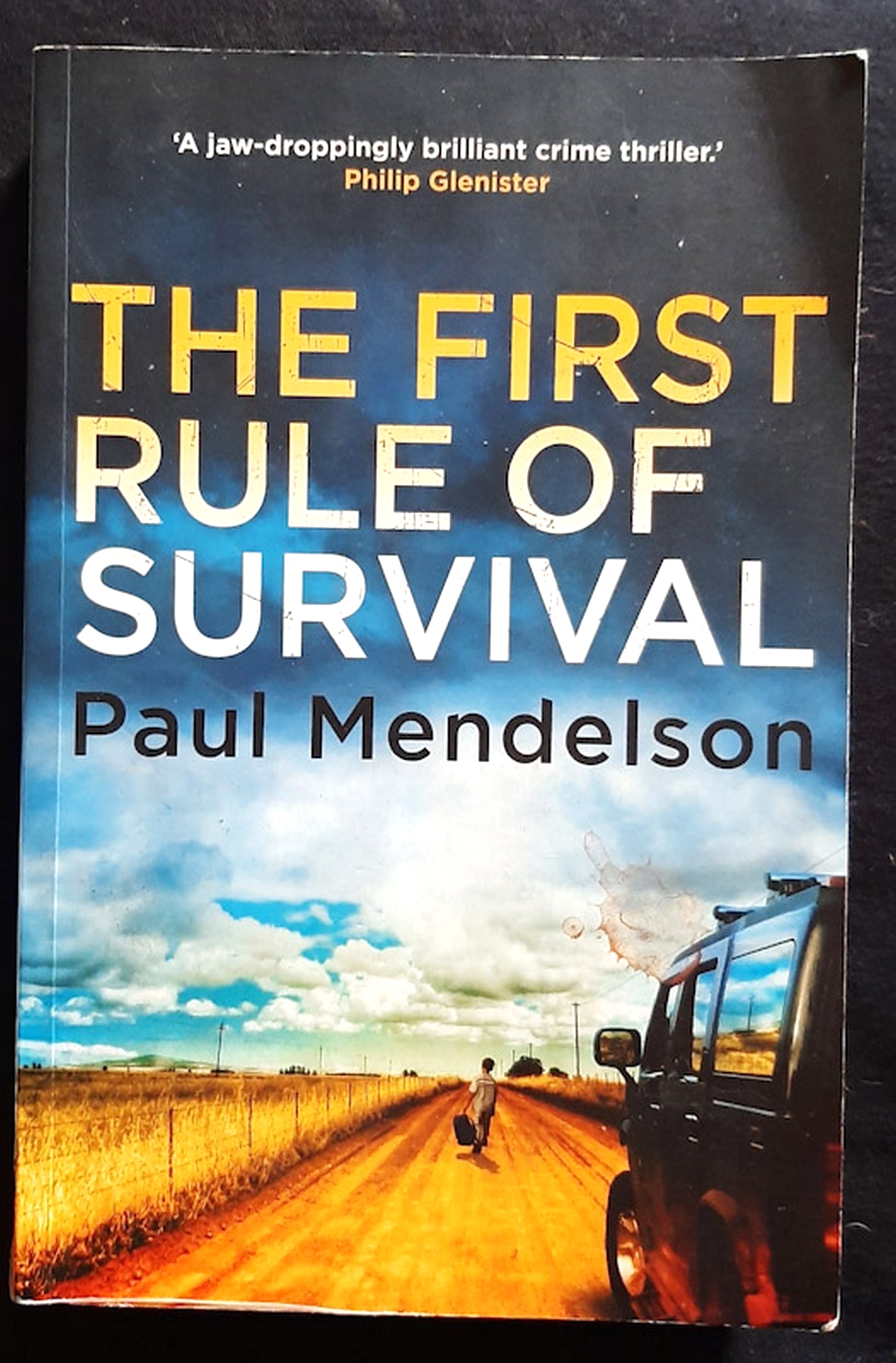 Front Cover Of The First Rule of Survival (Col Vaughn de Vries #1) (Paul Mendelson)